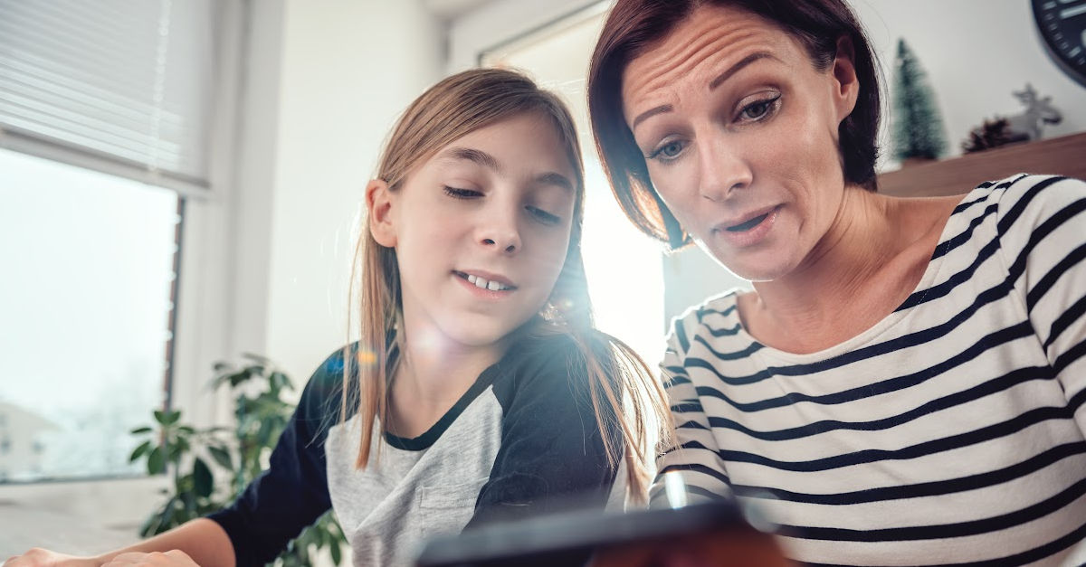 Parent showing teen son how to set up iPhone Screen Time parental controls